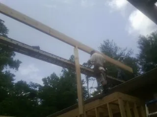 Carpenter setting a ridge beam over a new addition frame — Ice Dam Removal by Roofing Brothers in Gaylordsville