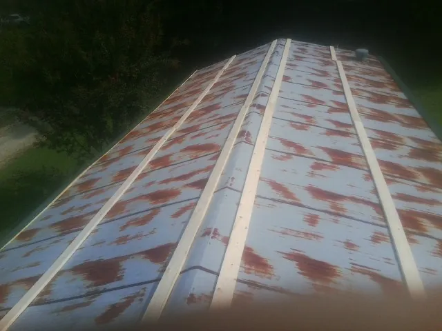 Rusted metal roof panels with new wood purlins before replacement — Storm Damage Roof Repair in Gaylordsville by Roofing Brothers