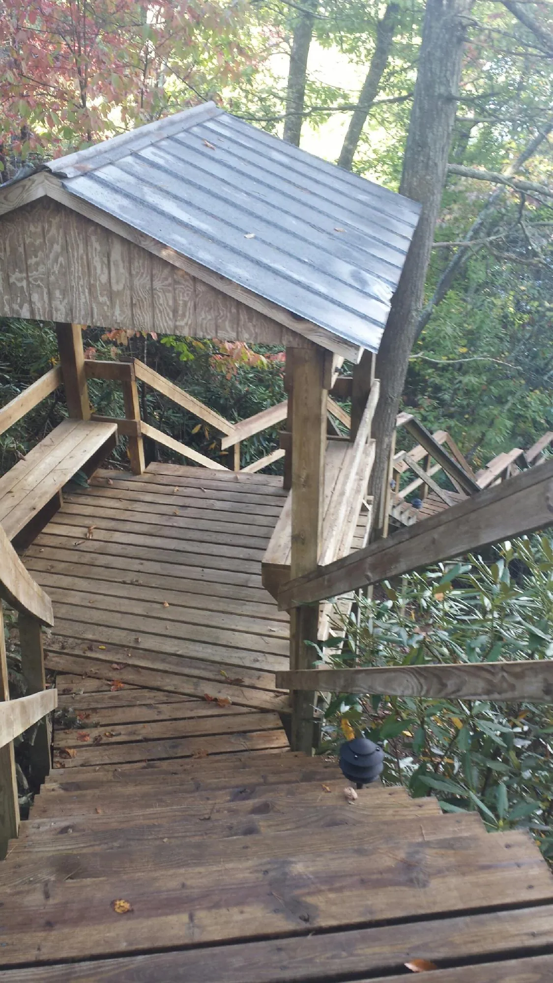 Metal roofed shelter over wooden steps on a wooded walkway — Skylight Repair & Installation work by our crew in Gaylordsville