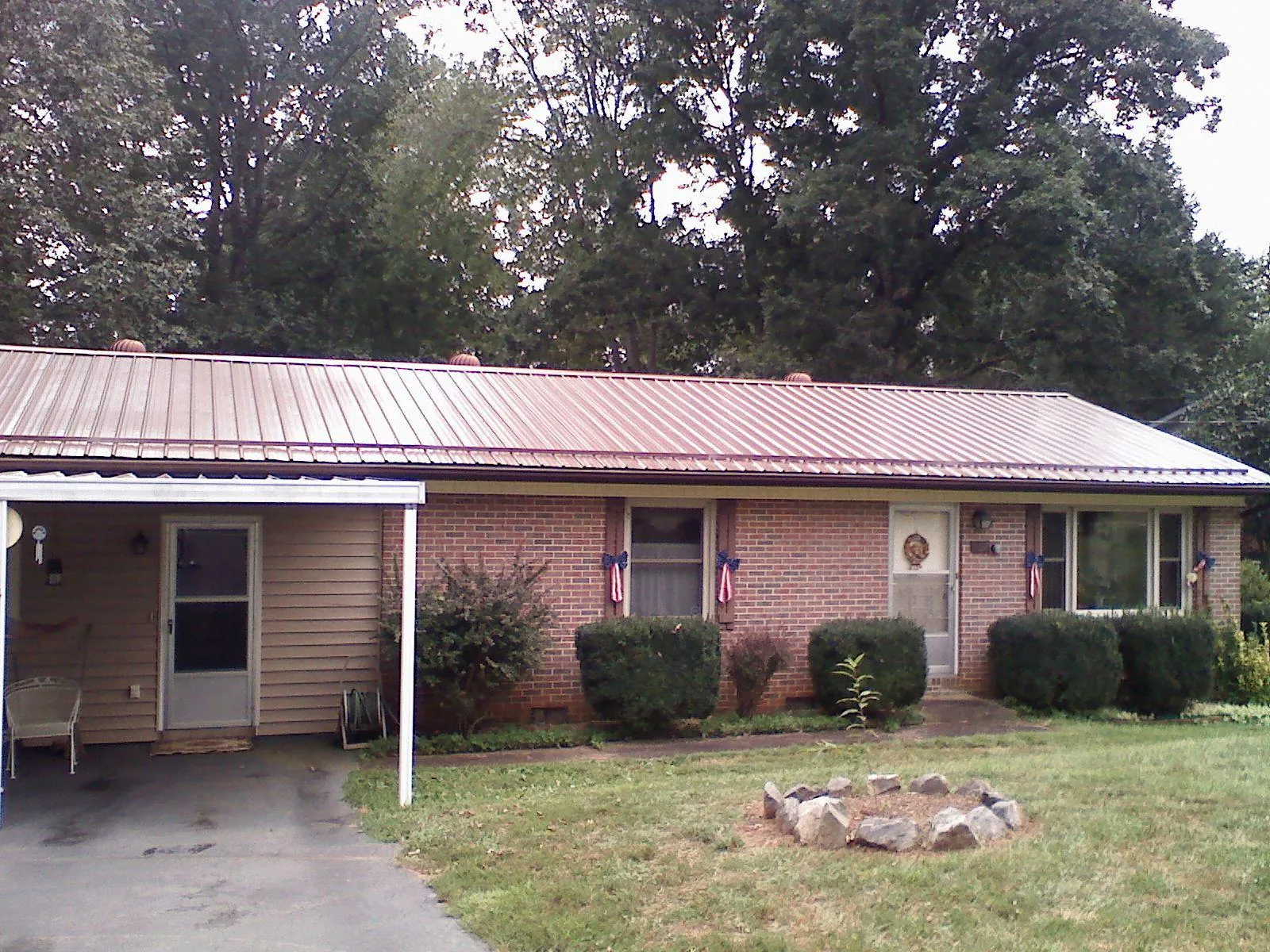 Bronze metal roof and carport on a brick ranch home — Roof Repair work by our crew in Gaylordsville
